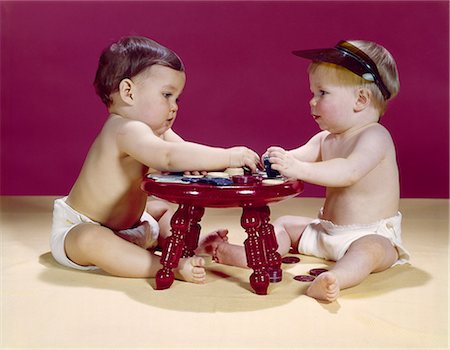 1960s TWO BABIES SITTING AT RED STOOL PLAYING CARDS POKER WITH GAMBLING CHIPS Stock Photo - Rights-Managed, Code: 846-03163915