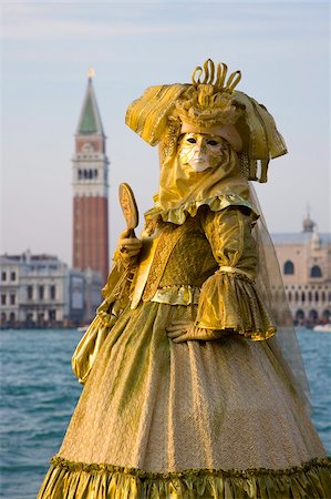 Masked carnival character in costume, the lagoon beyond, Campo San Giorgio, Island of San Giorgio Maggiore, Venice, Veneto, Italy, Europe Stock Photo - Rights-Managed, Code: 841-05781584