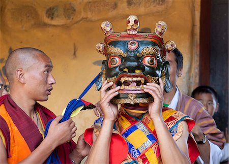 simsearch:841-05845843,k - Buddhist monk being helped to secure his carved wooden mask in readiness to take part in traditional dance at the Tamshing Phala Choepa Tsechu, near Jakar, Bumthang, Bhutan, Asia Stock Photo - Rights-Managed, Code: 841-05845852