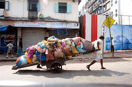 Laundrymen (dhobi wallahs), pulling wooden cart laden laundry from hotels for washing at Mahalaxmi dhobi ghats, Mumbai, India, Asia Stock Photo - Rights-Managed, Code: 841-05846619