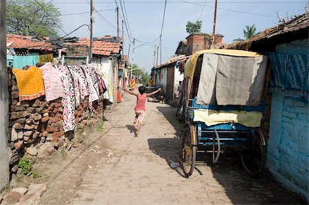 poverty - Child running down narrow street in Hooghly past cycle rickshaw and washing hanging over brick walls, West Bengal, India, Asia Stock Photo - Rights-Managed, Code: 841-05846649