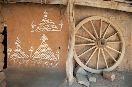 Village house wall with typical Orissa rice flour painting, and wooden cartwheel, Naupatana weaving village, rural Orissa, India, Asia Stock Photo - Rights-Managed, Code: 841-06447811