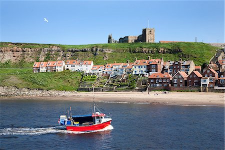 Fishing boat entering the harbour below Whitby Abbey, Whitby, North Yorkshire, Yorkshire, England, United Kingdom, Europe Stock Photo - Rights-Managed, Code: 841-06449087