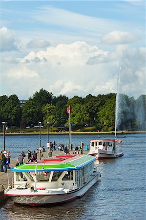Tour boats that ply Alster Lake moored at the Jungfernstieg with the Lombardsbruecke beyond, Hamburg, Germany, Europe Stock Photo - Rights-Managed, Code: 841-06502627