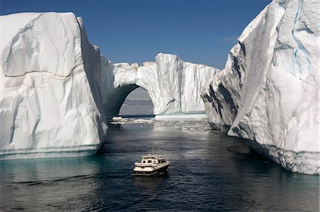 Icebergs in Disko Bay, natural arch and motorboat, UNESCO World Heritage Site, Ilulissat (Jakobshavn), Greenland, Denmark, Polar Regions Stock Photo - Rights-Managed, Code: 841-06805494