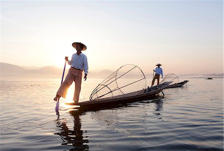 Intha leg rowing fishermen at dawn on Inle Lake who row traditional wooden boats using their leg and fish using nets stretched over conical bamboo frames, Inle Lake, Shan State, Myanmar (Burma), Asia Stock Photo - Rights-Managed, Code: 841-06805749
