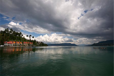 Monsoon clouds gathering over hotel on the edge of the still waters of volcanic Lake Toba, Sumatra Stock Photo - Rights-Managed, Code: 841-06806935