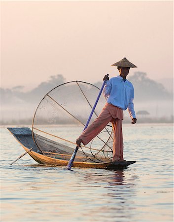 Intha 'leg rowing' fishermen at dawn on Inle Lake who row traditional wooden boats using their leg and fish using nets stretched over conical bamboo frames, Inle Lake, Myanmar (Burma), Southeast Asia Stock Photo - Rights-Managed, Code: 841-07081662