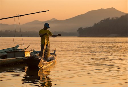Man reeling in fishing net on Mekong River, Luang Prabang, Laos, Indochina, Southeast Asia, Asia Stock Photo - Rights-Managed, Code: 841-07206439