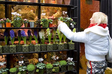 flower sale - Woman visits florist shop and chooses plant near Boulevard Saint Germain, Latin Quarter, Paris, France Stock Photo - Rights-Managed, Code: 841-07201783