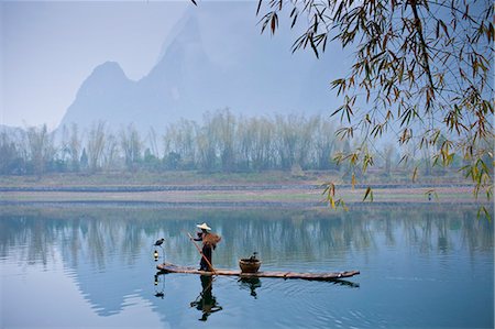 simsearch:841-07457244,k - Fisherman in Suoyi coat and coolie hat fishes with cormorants on Li River near Guilin, China Stock Photo - Rights-Managed, Code: 841-07457177