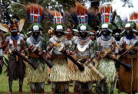 simsearch:855-03021954,k - Tribeswomen musicians in feathered headdresses grass skirts and face paints playing drums during  a gathering of tribes at Mount Hagen in Papua New Guinea Stock Photo - Rights-Managed, Code: 841-07523824