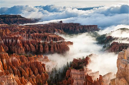 Pinnacles and hoodoos with fog extending into clouds of a partial temperature inversion, Bryce Canyon National Park, Utah, United States of America, North America Stock Photo - Rights-Managed, Code: 841-07600137