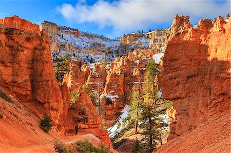 Hiker takes a break on the Peekaboo Loop Trail in winter, with snowy red rocks and cliffs, Bryce Canyon National Park, Utah, United States of America, North America Foto de stock - Con derechos protegidos, Código: 841-07673359