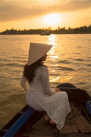 Woman wearing ao dai dress in boat at dawn, Can Tho, Mekong Delta, Vietnam, Indochina, Southeast Asia, Asia Stock Photo - Rights-Managed, Code: 841-08102083