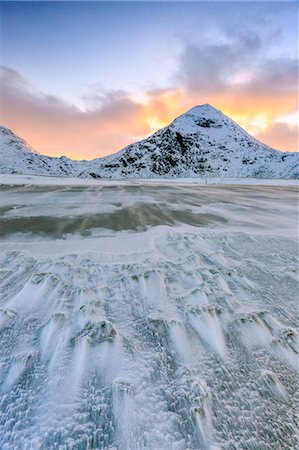 simsearch:841-08244166,k - Wave advances towards the shore of the beach surrounded by snowy peaks at dawn, Uttakleiv, Lofoten Islands, Arctic, Norway, Scandinavia, Europe Stock Photo - Rights-Managed, Code: 841-08244012