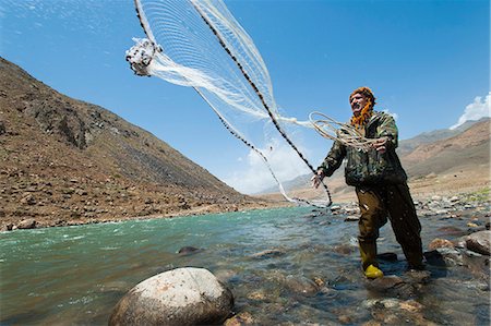 A man from the Panjshir Valley fishes with a throw-net, Afghanistan, Asia Stock Photo - Rights-Managed, Code: 841-08781767