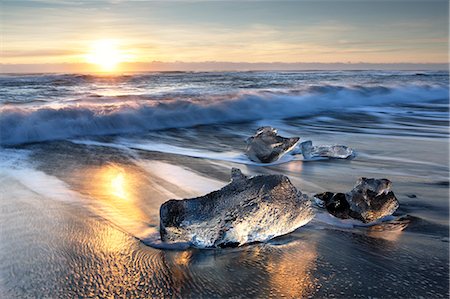 sunrise - Pieces of glacier ice washed up on black volcanic sand beach at sunrise, near Jokulsarlon Glacial Lagoon, South Iceland, Polar Regions Stock Photo - Rights-Managed, Code: 841-09077001