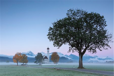 schwangau - Pink sunrise and mist of autumn on St. Coloman Church framed by snowy peaks, Schwangau, Bavaria, Germany, Europe Stock Photo - Rights-Managed, Code: 841-09085845