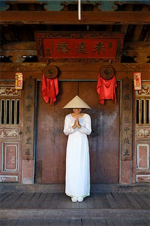 A young woman in a Non La conical hat and a traditional Ao Dai dress in the historical centre, Hoi An, Quang Nam, Vietnam, Indochina, Southeast Asia, Asia Stock Photo - Rights-Managed, Code: 841-09108120