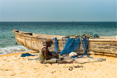 Man fixing their nets in their fishing boats on a beach in Robertsport, Liberia, West Africa, Africa Stock Photo - Rights-Managed, Code: 841-09147388