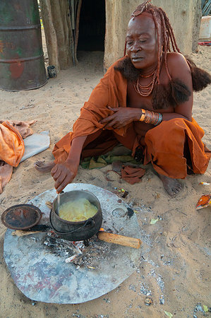 simsearch:841-06342688,k - One senior red ochred Himba woman cooking her meal on an open fire, Puros Village, near Sesfontein, Namibia, Africa Stock Photo - Rights-Managed, Code: 841-09194467