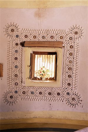 Raised mud reliefs inlaid with mirror on the walls of modern home in traditional tribal Rabari round mud hut, Bunga style, near Ahmedabad, Gujarat state, India, Asia Stock Photo - Rights-Managed, Code: 841-02704567