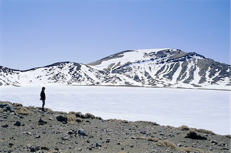 silhouette of man standing in a mountain top - Hiker on Tongariro Crossing trek by Blue Lake under winter ice and snow, Tongariro National Park, UNESCO World Heritage Site, Taupo, South Auckland, North Island, New Zealand, Pacific Stock Photo - Rights-Managed, Code: 841-02706843