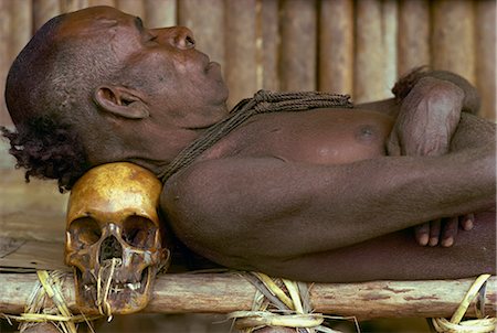 simsearch:841-02946644,k - An Asmat man sleeping with his head resting on a skull in Papua New Guinea, Pacific Stock Photo - Rights-Managed, Code: 841-02711511