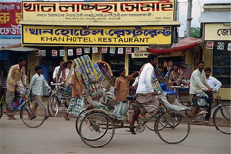 simsearch:841-02947131,k - Men riding cycle rickshaws on the street passing the outside of a hotel and restaurant in the city of Dhaka (Dacca), Bangladesh, Asia Stock Photo - Rights-Managed, Code: 841-02712152