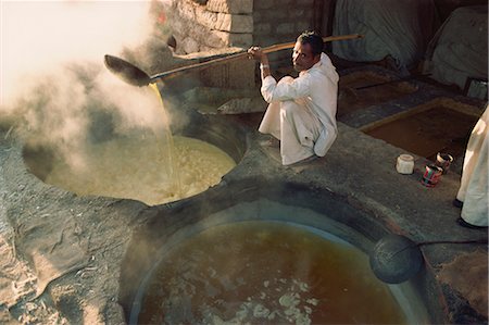 Boiling off water from cane juice to make jaggery (sugar), after sugar cane harvest, Gujarat state, India, Asia Stock Photo - Rights-Managed, Code: 841-02900261
