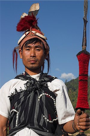 feather headdress tribe pictures - Naga man holding spear and wearing headdress of woven cane decorated with wild boar teeth, bear fur, red dyed goats hair and hornbill feathers, Naga New Year Festival, Lahe village, Sagaing Division, Myanmar (Burma), Asia Stock Photo - Rights-Managed, Code: 841-02916999