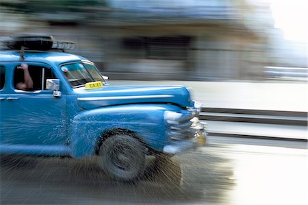 simsearch:841-03507904,k - Panned shot of old American car splashing through puddle on Prado, Havana, Cuba, West Indies, Central America Stock Photo - Rights-Managed, Code: 841-02918000