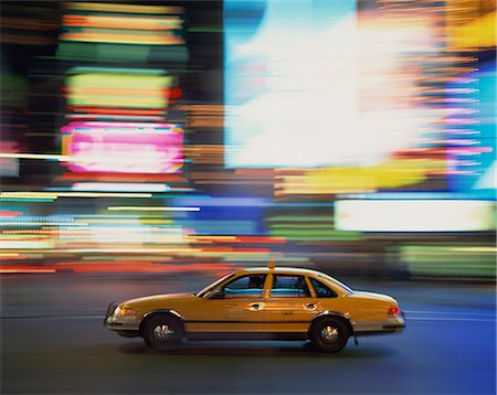 Yellow cab driving past blurred neon lights at night in Times Square in New York, United States of America, North America Stock Photo - Rights-Managed, Code: 841-02918474