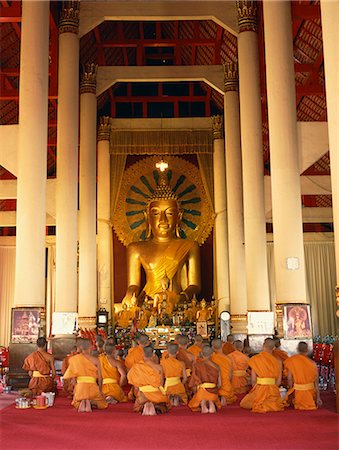 simsearch:841-02925433,k - Monks in saffron robes kneel before a statue of the Buddha in Wat Phra Sing in Chiang Mai, Thailand, Southeast Asia, Asia Stock Photo - Rights-Managed, Code: 841-02918521