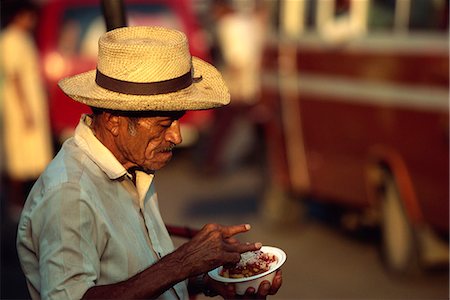 simsearch:841-07081838,k - Portrait of an elderly man in a straw hat eating a snack in San Miguel, El Salvador, Central America Stock Photo - Rights-Managed, Code: 841-03067556