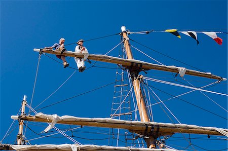 furling - Detail of main mast of tall ship with two seamen on top yard securing sail, Whitehaven, Cumbria, England, United Kingdom, Europe Stock Photo - Rights-Managed, Code: 841-03061221