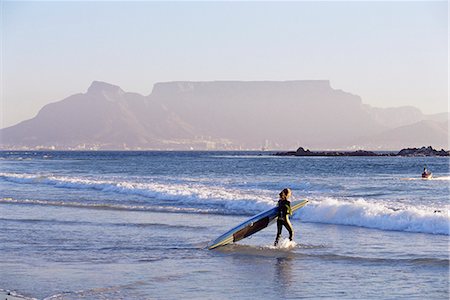 simsearch:841-03061953,k - Young woman surfer enters the water of the Atlantic Ocean with Table Mountain in the background, Cape Town, South Africa, Africa Stock Photo - Rights-Managed, Code: 841-03061910