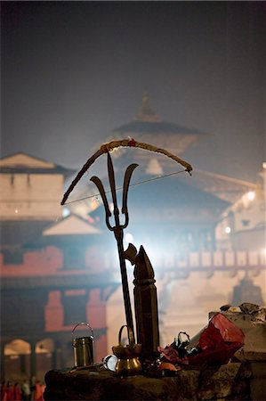 A holy man's bow placed on a bronze sculpture of a Shiva trident, Hindu festival of Shivaratri, Pashupatinath, Kathmandu, Nepal, Asia Stock Photo - Rights-Managed, Code: 841-03062404