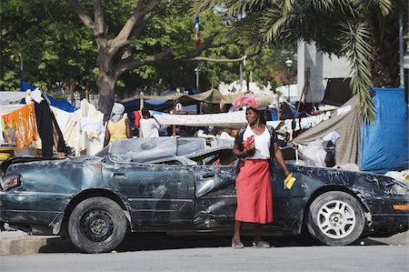 damaged - Woman in front of a damaged car, January 2010 earthquake, downtown, Port au Prince, Haiti, West Indies, Caribbean, Central America Foto de stock - Con derechos protegidos, Código: 841-03672779