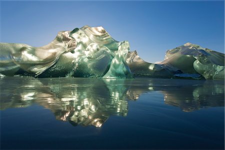 An iceberg, trapped in the frozen waters of Mendenhall Lake glowing and backlit with the morning sun, Juneau, Southeast Alaska, Winter Stock Photo - Rights-Managed, Code: 854-05974194