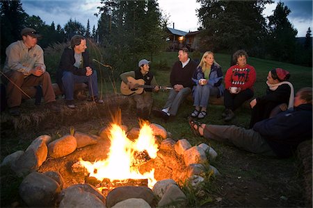 simsearch:846-02794130,k - Group of adults sitting around a campfire sing and and talk as they enjoy the warmth of the fire and each others company at Winter Lake Lodge. Summer in Southcentral Alaska. Stock Photo - Rights-Managed, Code: 854-02955472