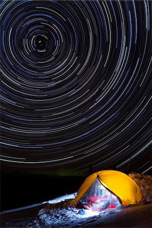 Star trails circle above a lit tent during Winter on Wrangell Island in Southeast Alaska, Tongass National Forest Stock Photo - Rights-Managed, Code: 854-03361774