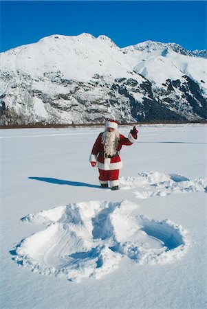 Santa waving after having made a snow angel in fresh snow Stock Photo - Rights-Managed, Code: 854-03362346