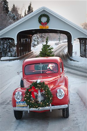 Man driving a vintage 1941 Ford pickup through a covered bridge with a Christmas wreath on the grill and a tree in the back during Winter in Southcentral, Alaska Stock Photo - Rights-Managed, Code: 854-03362342