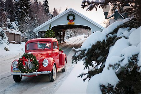 Man driving a vintage 1941 Ford pickup through a covered bridge with a Christmas wreath on the grill and a tree in the back during Winter in Southcentral, Alaska Stock Photo - Rights-Managed, Code: 854-03539001