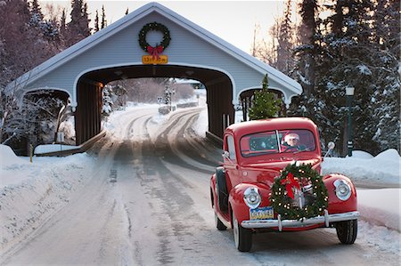 Man driving a vintage 1941 Ford pickup through a covered bridge with a Christmas wreath on the grill and a tree in the back during Winter in Southcentral, Alaska Stock Photo - Rights-Managed, Code: 854-03539002