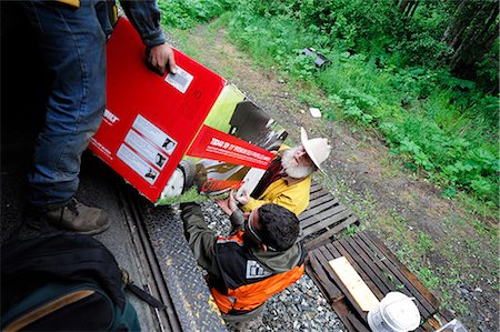 railroad worker - Alaska Railroad conductor helps a homestead passenger unload at his stop during a whistle stop along the Hurricane Turn route, Interior Alaska, Summer Foto de stock - Con derechos protegidos, Código: 854-03646438