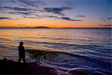 simsearch:854-03362156,k - Silhouette of a man standing on the shore of Knik Arm while watching  the sunset over Mount Susitna, Southcentral Alaska, Summer Stock Photo - Rights-Managed, Code: 854-03646614