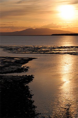 simsearch:854-03362156,k - View of the sun setting over Mt. Susitna (Sleeping Lady) with Cook Inlet in the foreground, Anchorage, Southcentral Alaska, Summer Stock Photo - Rights-Managed, Code: 854-03646662